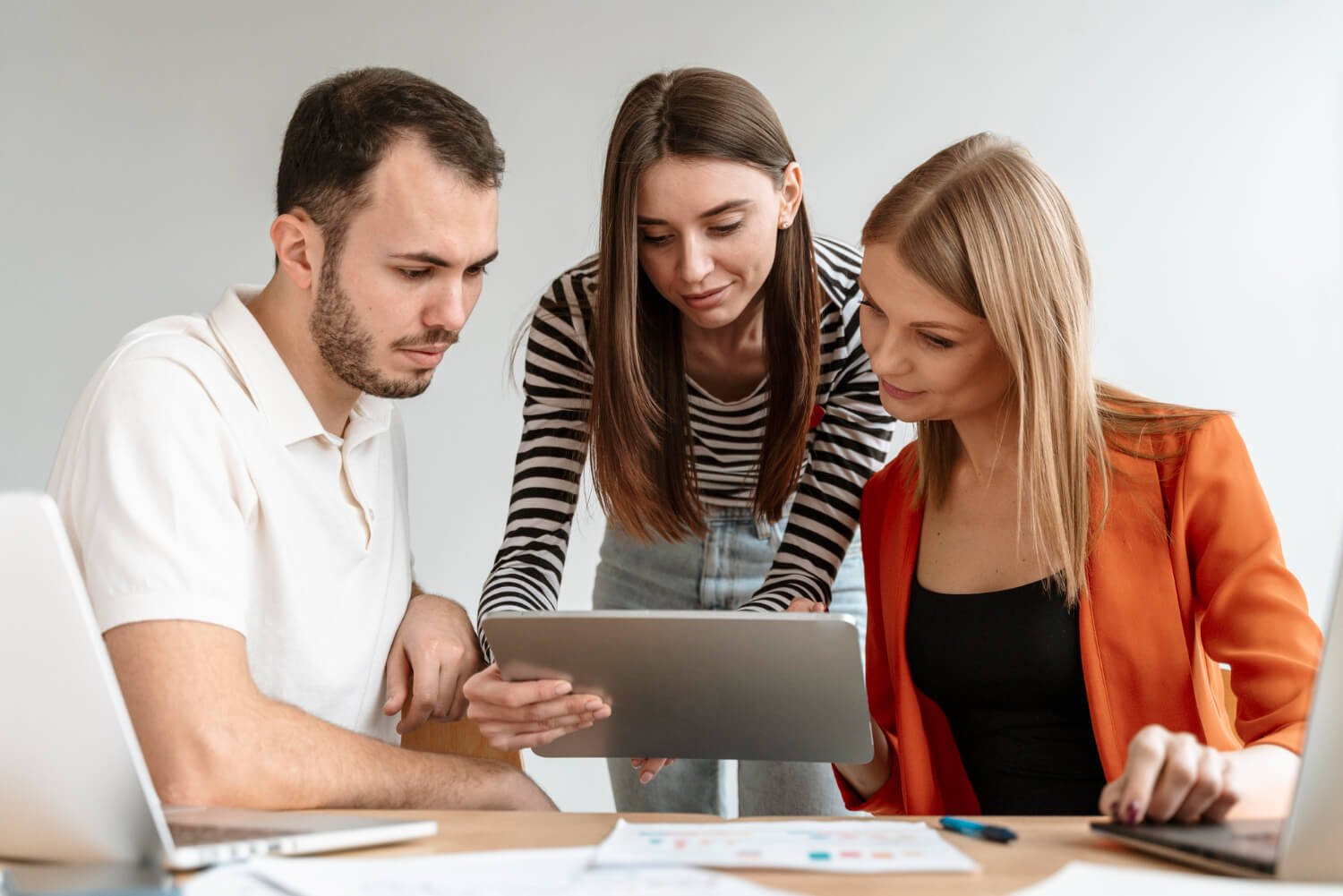 Team sidder sammen og ser på en tablet