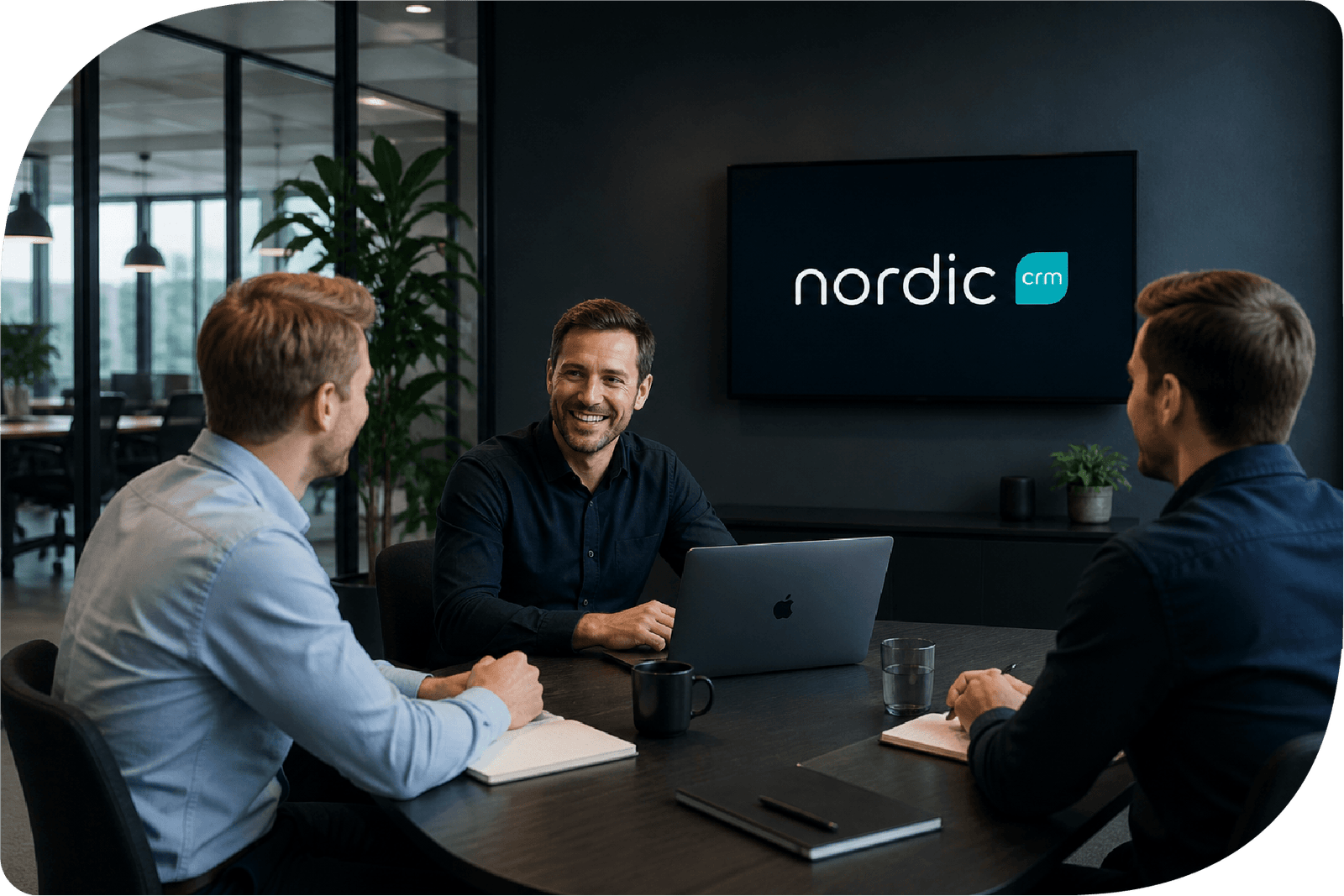 Teammøde hos Nordic CRM hvor medarbejdere diskuterer CRM løsninger og digitale processer i moderne kontormiljø.